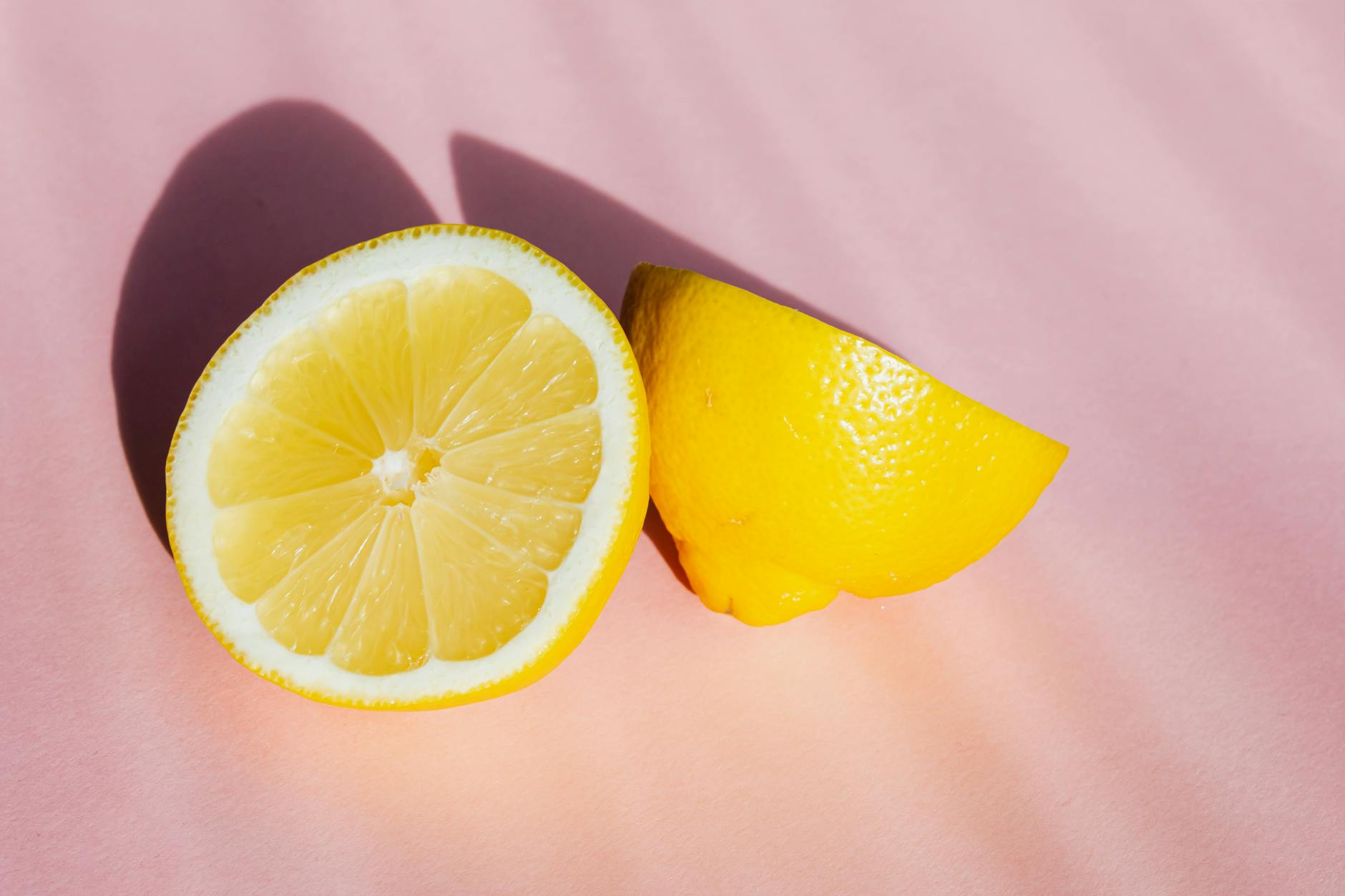 Fresh lemons on a pink background in natural sunlight, symbolizing the refreshing novelty of discovering new pleasure