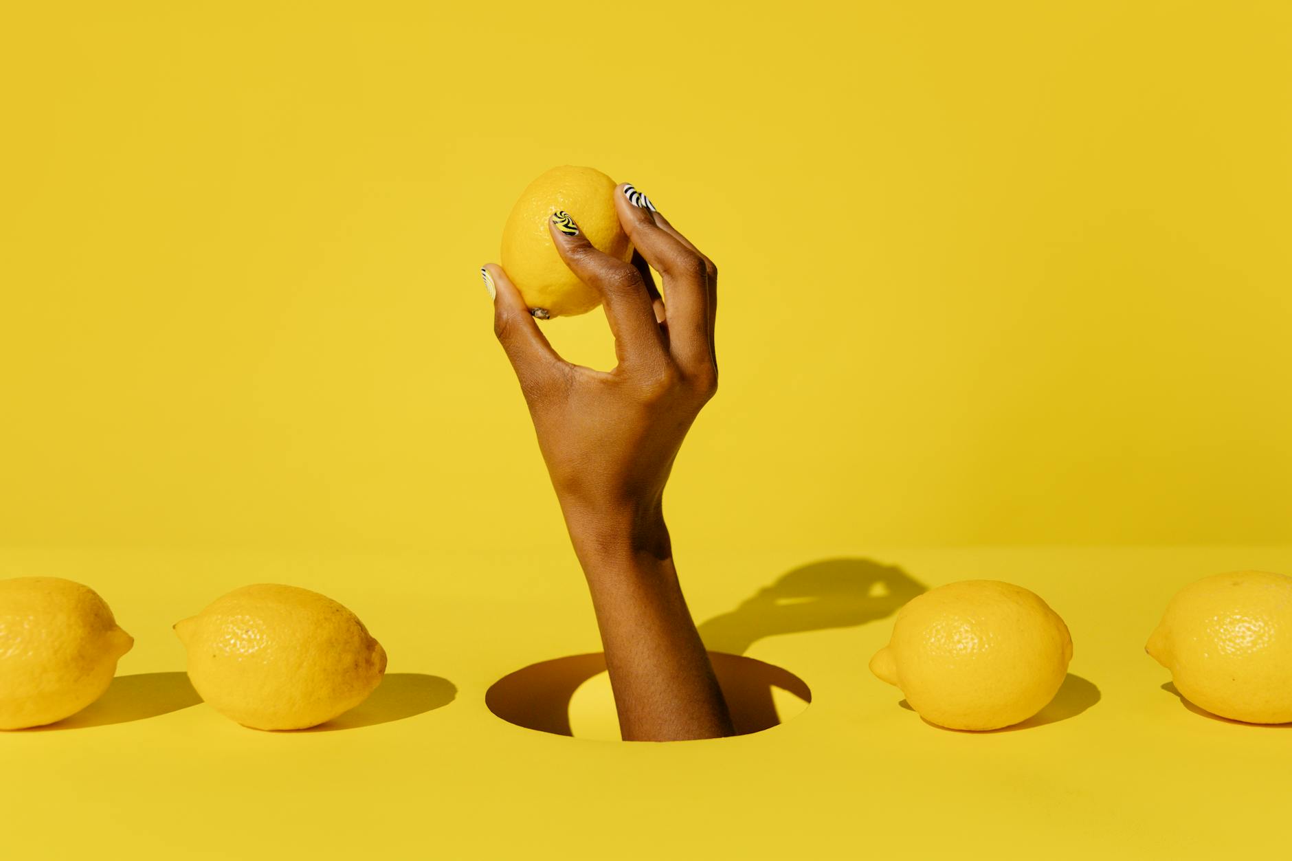 Fresh whole lemons arranged with stacked books on white fabric