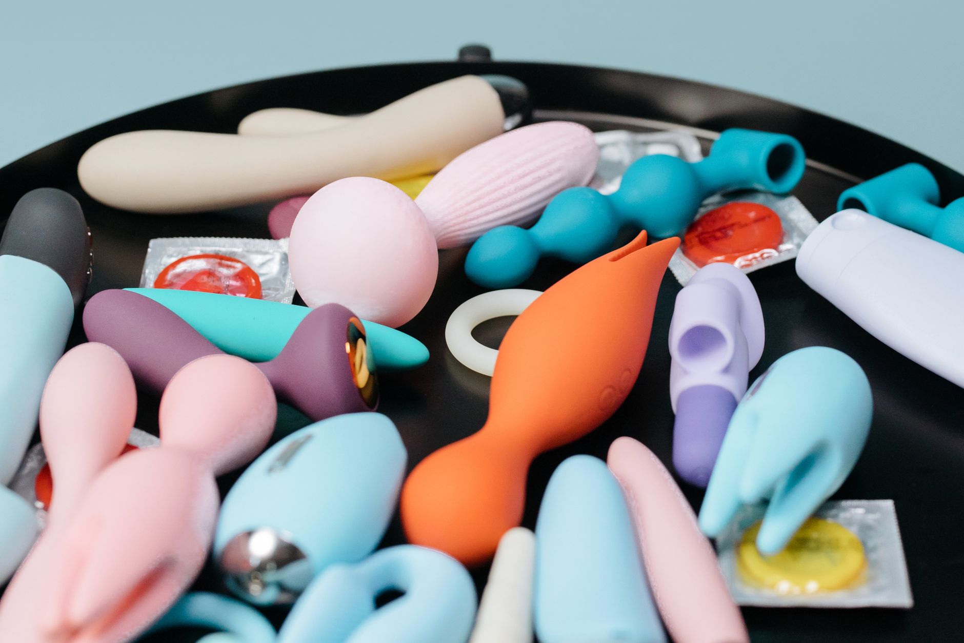 Close-up of hands holding silicone vibrators, representing safe pleasure tools for recovery