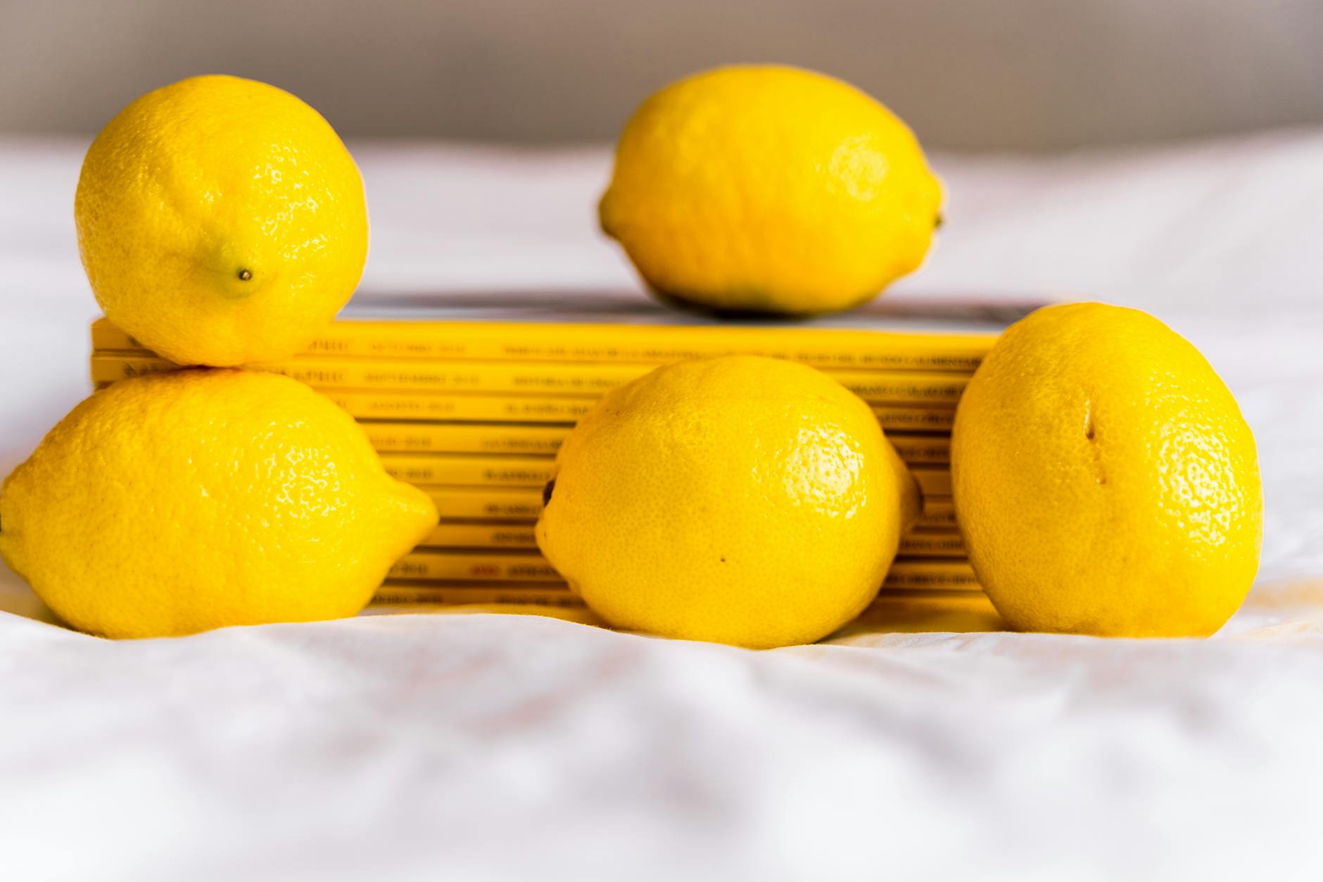 Two vibrant lemons on a minimalistic white background, symbolizing fresh, approachable pleasure